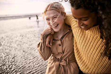 Two friends walking together and smiling